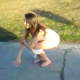 A girl is video-recorded by her friends as she takes a piss on the street.